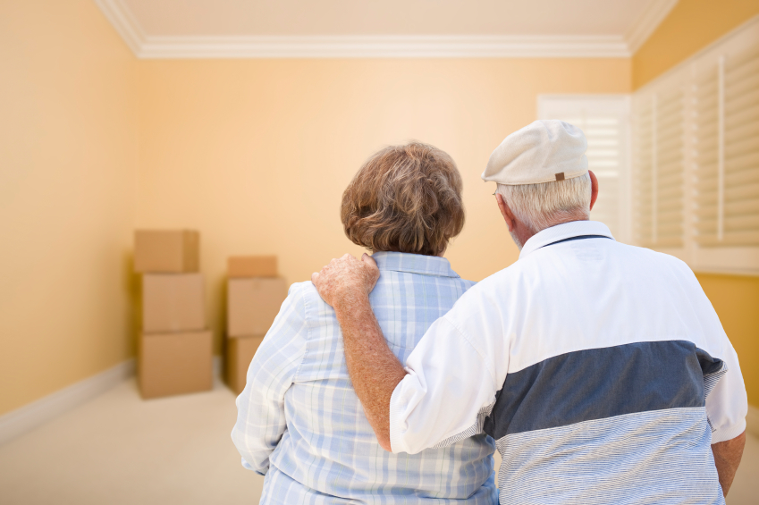 Hugging Senior Couple Looking at Moving Boxes